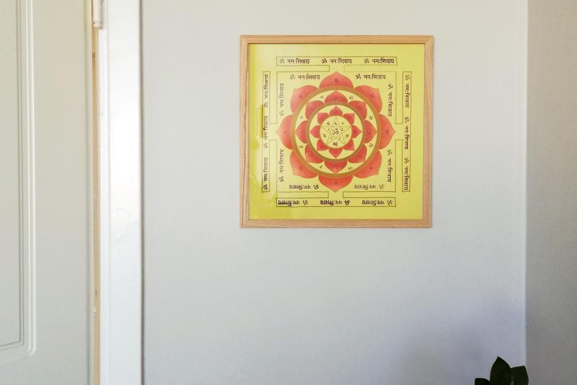 Illustration in yellow and red, framed, on wall.
